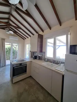 a large kitchen with white cabinets and a large window at Sunset Retreat Cyprus in Pendakomo