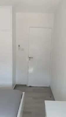 a white room with two white doors and a wooden floor at Prestige Worldwide Apartments in Ayia Napa
