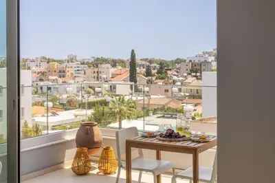 a dining room table with a view of a city at Rodoni Residence in Strovolos