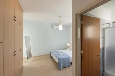 a bedroom with a bed with a blue blanket at Protaras Sunrise Zen Seafront Villa in Protaras