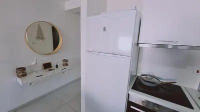 a white refrigerator in a kitchen with a mirror at STAY Kallucci's maison de la mer in Larnaka
