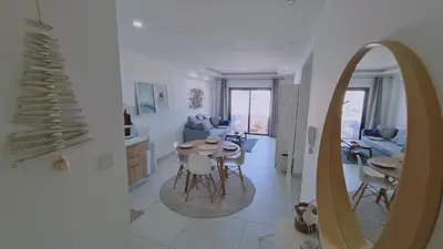 a living room with a table and a mirror at STAY Kallucci's maison de la mer in Larnaka