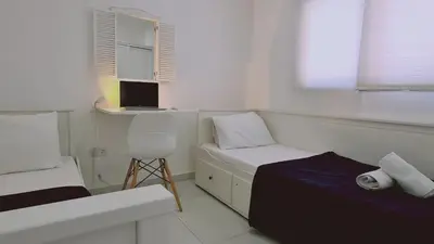 a white room with a bed and a laptop on a desk at STAY Kallucci's maison de la mer in Larnaka
