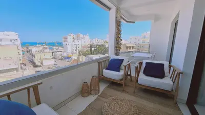 a balcony with two chairs and a view of a city at STAY Kallucci's maison de la mer in Larnaka