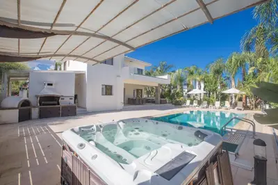 a swimming pool with a hot tub and a house at Demetra Villa in Ayia Napa