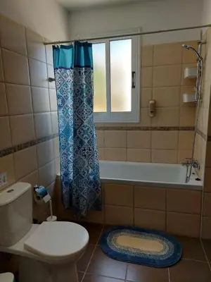 a bathroom with a toilet and a tub and a window at Pyla Palms A2 107 in Pyla