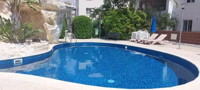 a large swimming pool with blue water in a yard at Pyla Palms A2 107 in Pyla