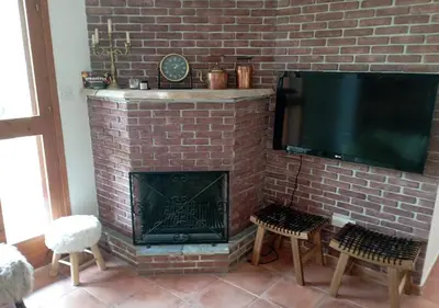 a brick fireplace with a flat screen tv on it at Vavatsinia Panorama Cottage in Vavatsinia