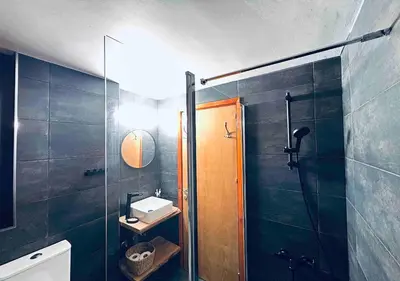 a bathroom with a glass shower and a sink at Vavatsinia Panorama Cottage in Vavatsinia