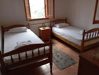 a bedroom with two beds and a window at Vavatsinia Panorama Cottage in Vavatsinia