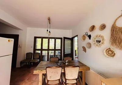 a dining room with a wooden table and chairs at Vavatsinia Panorama Cottage in Vavatsinia
