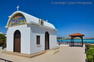 a small chapel on the beach with the ocean in the background at Nissi 3 Pool View Apartment in Ayia Napa