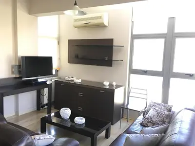 a living room with a couch and a flat screen tv at Alex Residence in Larnaka