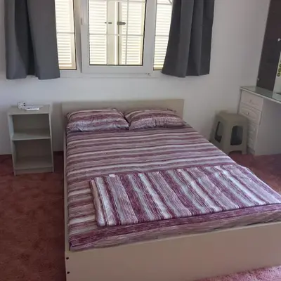 a bed with a striped blanket in a bedroom at Vasilis House family room in Larnaka