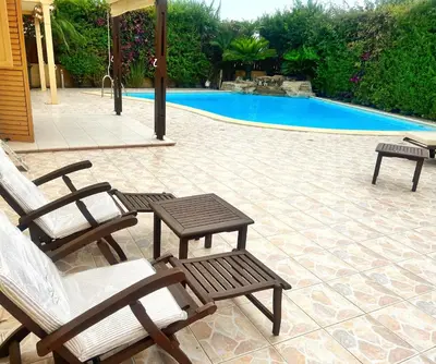 a couple of chairs and a table next to a pool at Villa Victoria Ayia Napa in Ayia Napa