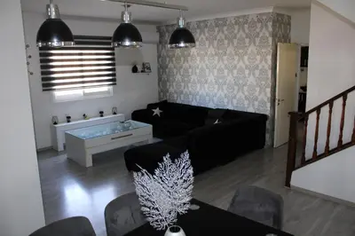a living room with a black couch and a table at Trudy's home in Nicosia