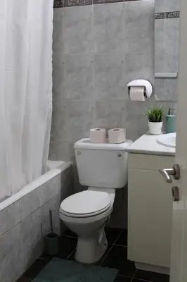 a bathroom with a toilet and a tub and a sink at Trudy's home in Nicosia
