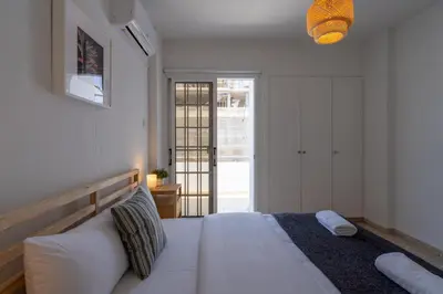 a bedroom with a large white bed and a window at Blossom 1-Bedroom Apartment in Larnaca in Larnaka