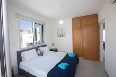 a bedroom with a bed with blue towels on it at Pelagos Villa 8 in Protaras