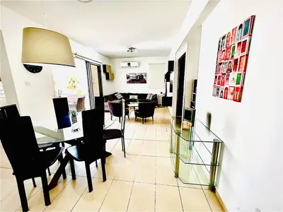 a dining room and living room with a table and chairs at LARA 303 in Larnaka