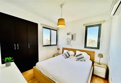 a bedroom with a white bed and two windows at LARA 303 in Larnaka
