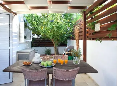 a wooden table with fruit and drinks on a patio at Villa Kos 19 in Protaras
