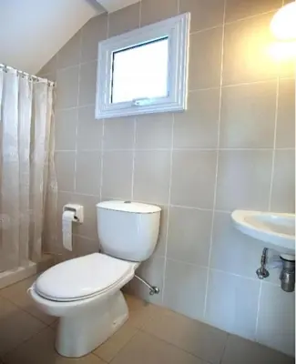 a bathroom with a toilet and a sink and a window at Villa Kos 19 in Protaras