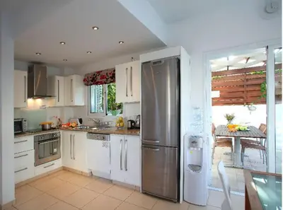 a kitchen with white cabinets and a stainless steel refrigerator at Villa Kos 19 in Protaras