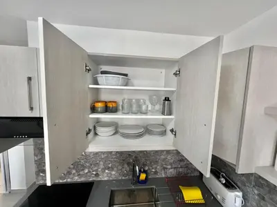a kitchen with white cabinets and a sink and plates at Stay With Oleg C111 in Paralimni