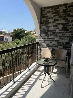 a balcony with two chairs and a table and a brick wall at Stay With Oleg C111 in Paralimni