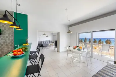 a kitchen and dining room with a view of the ocean at Protaras H2O Seafront Suite in Protaras