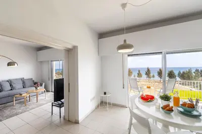 a living room with a table and a couch at Protaras H2O Seafront Suite in Protaras