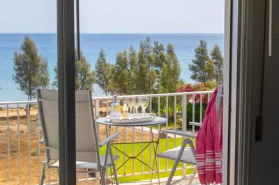 a table and chairs on a balcony with a view of the ocean at Protaras H2O Seafront Suite in Protaras
