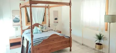 a bedroom with a wooden canopy bed in a room at Villa Christina in Protaras