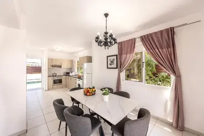 a kitchen and dining room with a table and chairs at Nissini villa in Ayia Napa