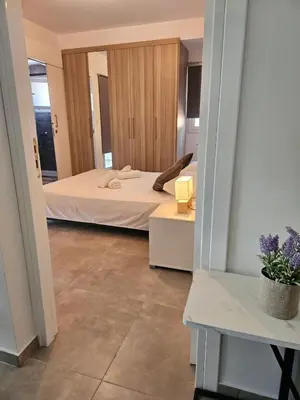 a bedroom with a bed and a table with a plant at SC_apartments in Kato Pyrgos