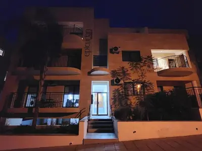 a building with a hallway leading to a door at night at Epicurian Residence in Nicosia