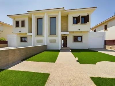 a house with a green lawn in front of it at Fabulous beach front house with pool in Larnaka