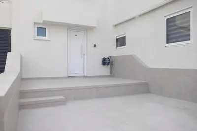 a white house with a white door and stairs at Lovely Studio by the Beach in Voroklini