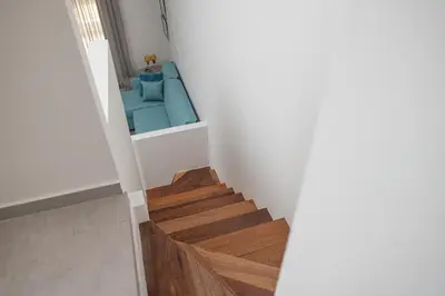 a staircase in a house with a blue couch at Lovely Studio by the Beach in Voroklini