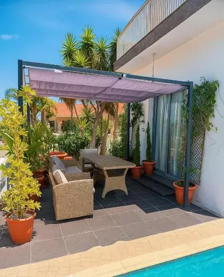 a patio with a table and chairs and plants at Tereza's House in Ayvaryara