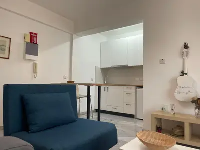 a living room with a blue couch and a kitchen at Nicosia Downtown Cozy in Nicosia