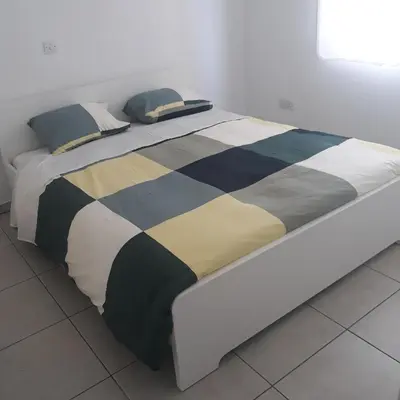 a bed with pillows on it in a room at A CHEERFUL APARTMENT in a popular area in Pallouriotissa