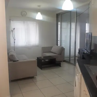 a living room with a couch and a chair at A CHEERFUL APARTMENT in a popular area in Pallouriotissa
