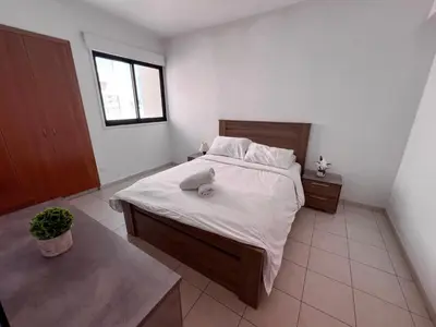 a bedroom with a large bed with white sheets at Mackenzie apartment 301 in Larnaka