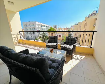 a living room with a couch and chairs on a balcony at Mackenzie apartment 301 in Larnaka