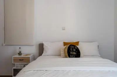 a bed with white sheets and a pillow on it at Flair - 1-Bedroom Apartment & Balcony in Larnaca in Larnaka