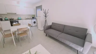 a living room with a couch and a table and a kitchen at STAY Sand Flat in Paralimni