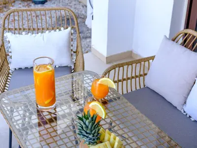 a glass table with orange juice and fruit on it at Cute & Cozy Mazotos 1bed Getaway in Mazotos