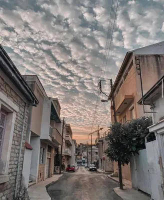 an empty street with a cloudy sky in a city at Charming House in the Heart of Limassol in Limassol